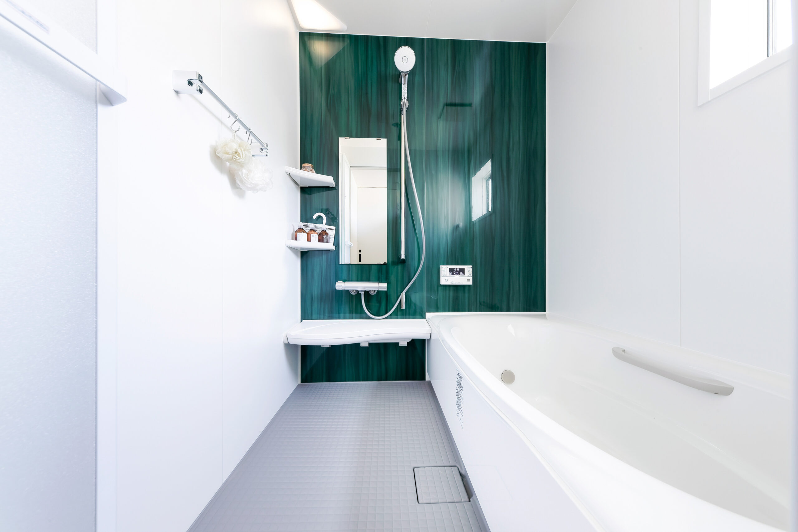 このモデルハウスのテーマカラーでもあるグリーンのパネルを使用した浴室。
